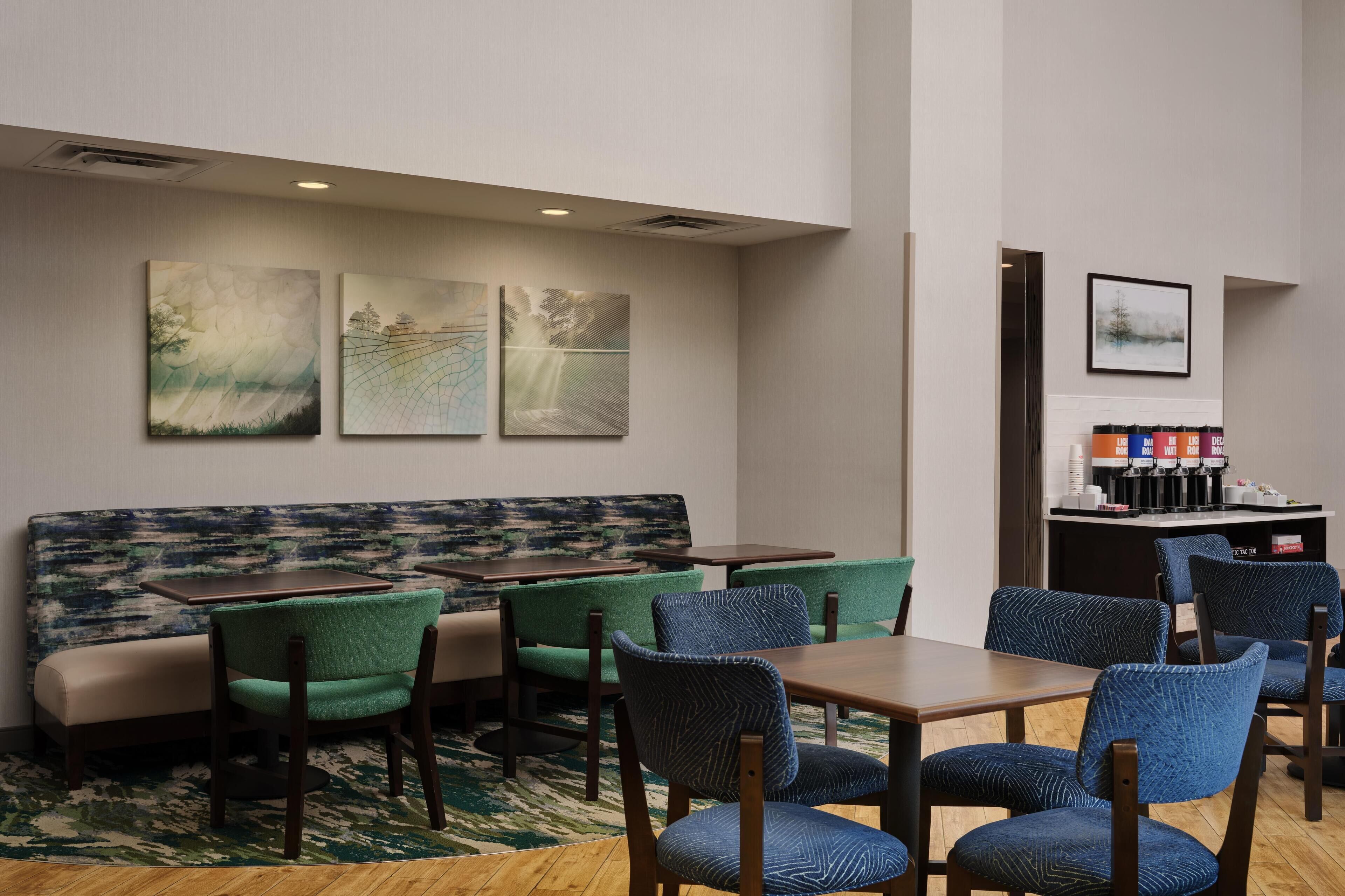 Ein Hotelzimmer mit einer Couch, Stühlen, einem Tisch und Kunstwerken an den Wänden.