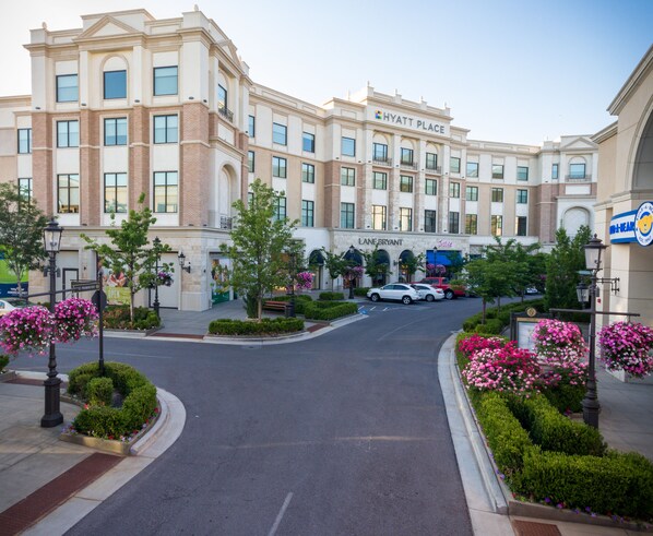 A hotel with a central courtyard, a main entrance, and a parking area.