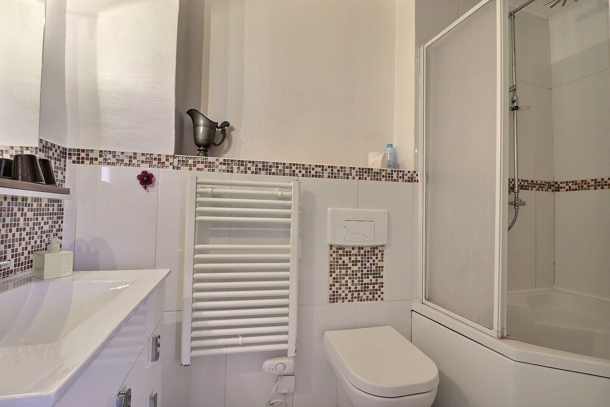 A bathroom with a white bathtub, toilet, and shower.