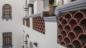 A white building with arched windows and terracotta roof tiles. - Hotel Colonial (Manzanillo)
