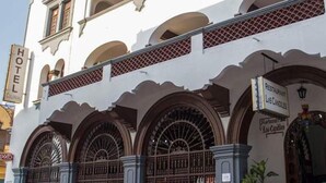 A colonial-style hotel with arched windows and a sign for a restaurant. - Hotel Colonial (Manzanillo)