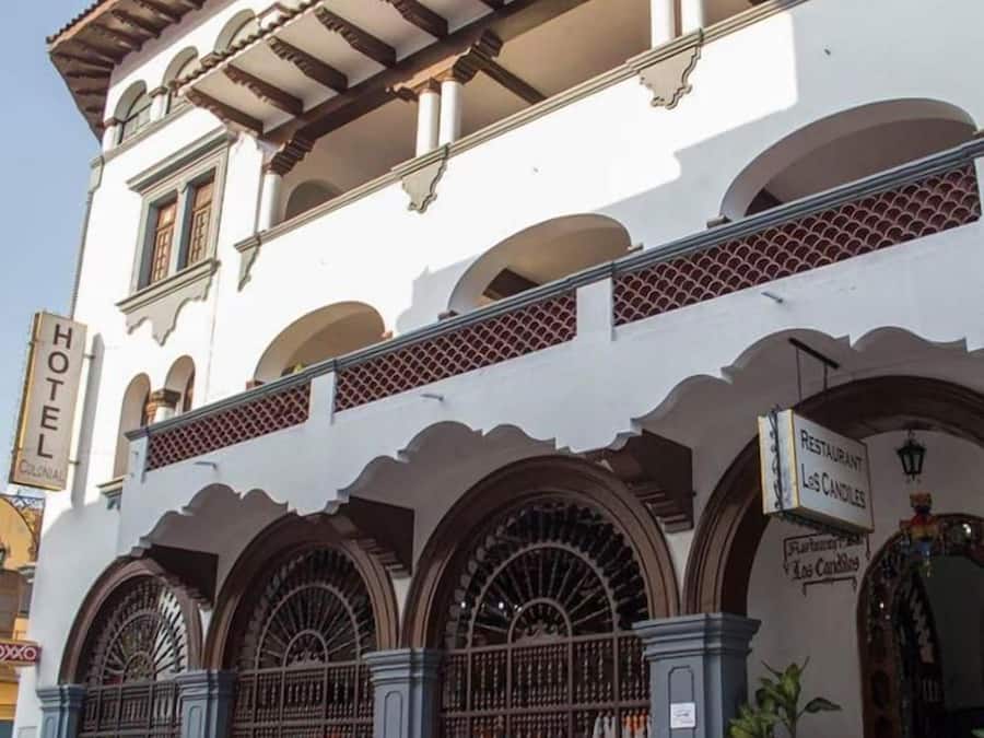 A colonial-style building with multiple arches and a sign indicating a restaurant named "Los Candiles."