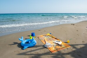 A beach with a blanket, a hat, a book, and inflatable toys. - Hotel President Sea Palace (Noto)