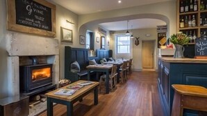 A cozy pub with a fireplace, wooden furniture, and a bar area. - The Redan (Radstock)