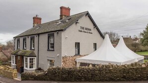 A traditional building labeled "The Redan" with a stone facade, a small porch, and a white tent-like structure in front. - The Redan (Radstock)