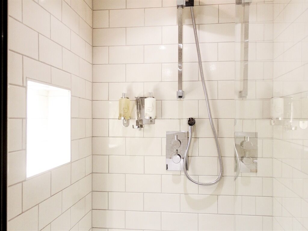 Eine Dusche mit Handbrause und einer fest installierten Bedienung.