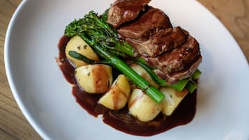 Ein Teller Essen mit Fleisch, Kartoffeln und grünen Bohnen.