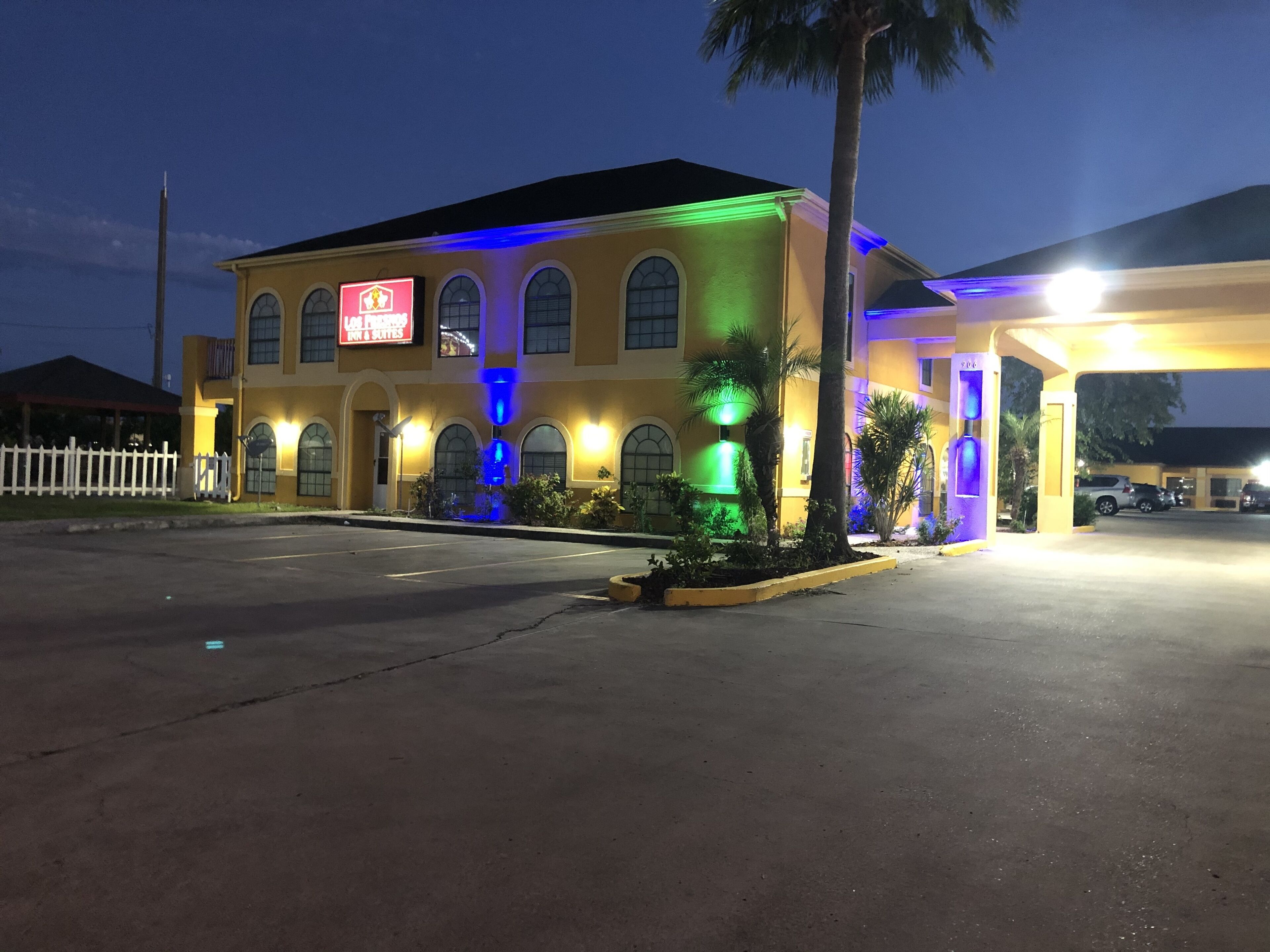 A hotel with a yellow facade, arched windows, and a sign indicating it is a restaurant.