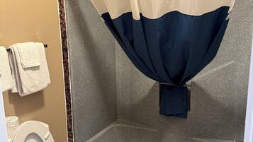 A bathroom with a shower, a toilet, and a towel rack.