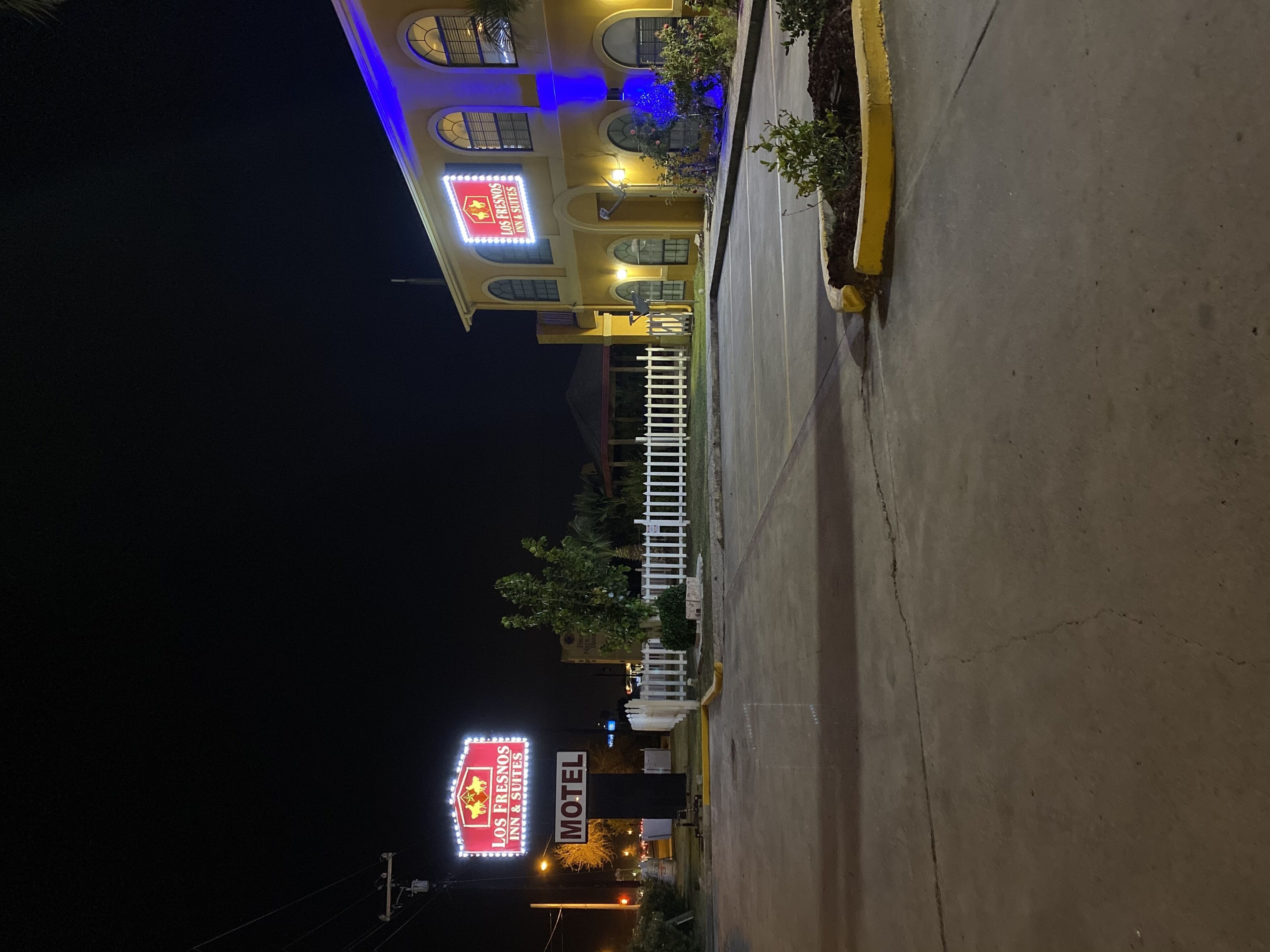A motel with a prominent sign for Los Fresnos Inn & Suites.