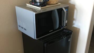 A compact kitchen setup with a microwave and a refrigerator.