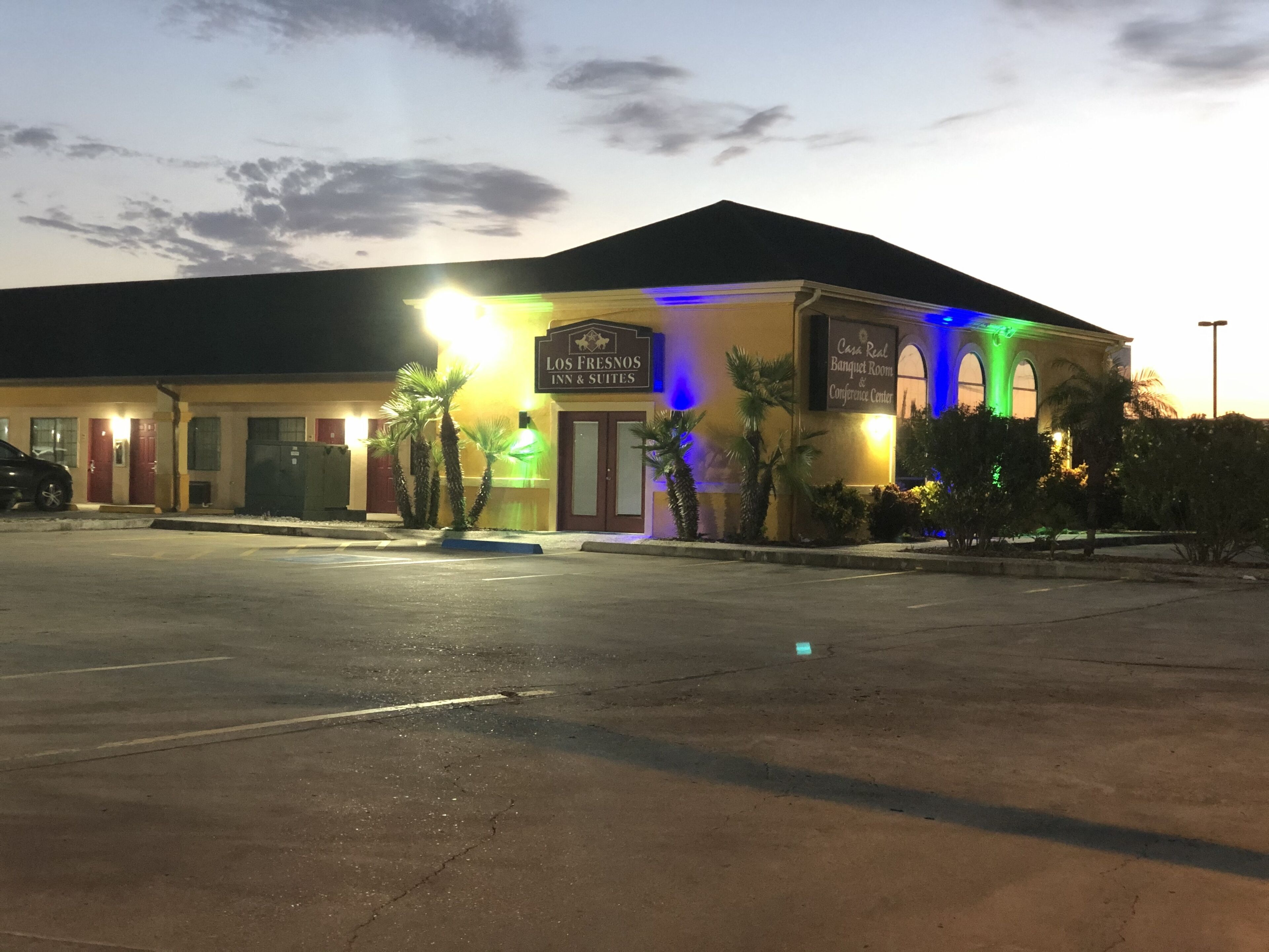 A hotel with a sign for 'Los Fresnos Inn & Suites' and a 'Banquet Room & Conference Center'.