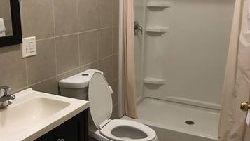 A bathroom with a toilet, sink, and shower.