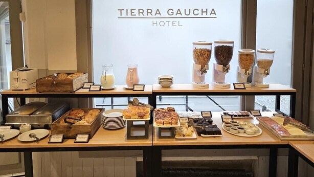 A buffet setup at Tierra Gaucha Hotel with various food items and condiments. - Hotel Tierra Gaucha (San Carlos de Bariloche)