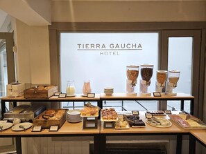 A buffet setup at Tierra Gaucha Hotel with various food items and condiments. - Hotel Tierra Gaucha (San Carlos de Bariloche)