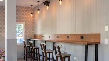 A bar area with wooden stools and a long counter.