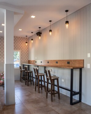 Una zona de bar con taburetes de madera y una barra larga.