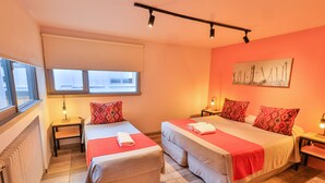 A hotel room with two beds, a window, a radiator, and a painting on the wall. - Hotel Tierra Gaucha (San Carlos de Bariloche)