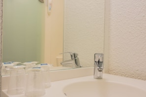 Bathroom features a sink, faucet, and mirror with storage.