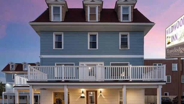 A two-story building with a balcony and a sign for Wildwood Inn.