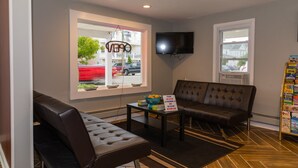 A modern living room with a sofa, a coffee table, and a television mounted on the wall.