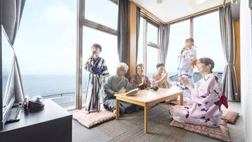 Un grupo de personas en una habitación con ventanas amplias, una mesa y vistas al mar.