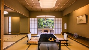Una habitación japonesa tradicional con suelo de tatami, una mesa baja y puertas correderas shoji.