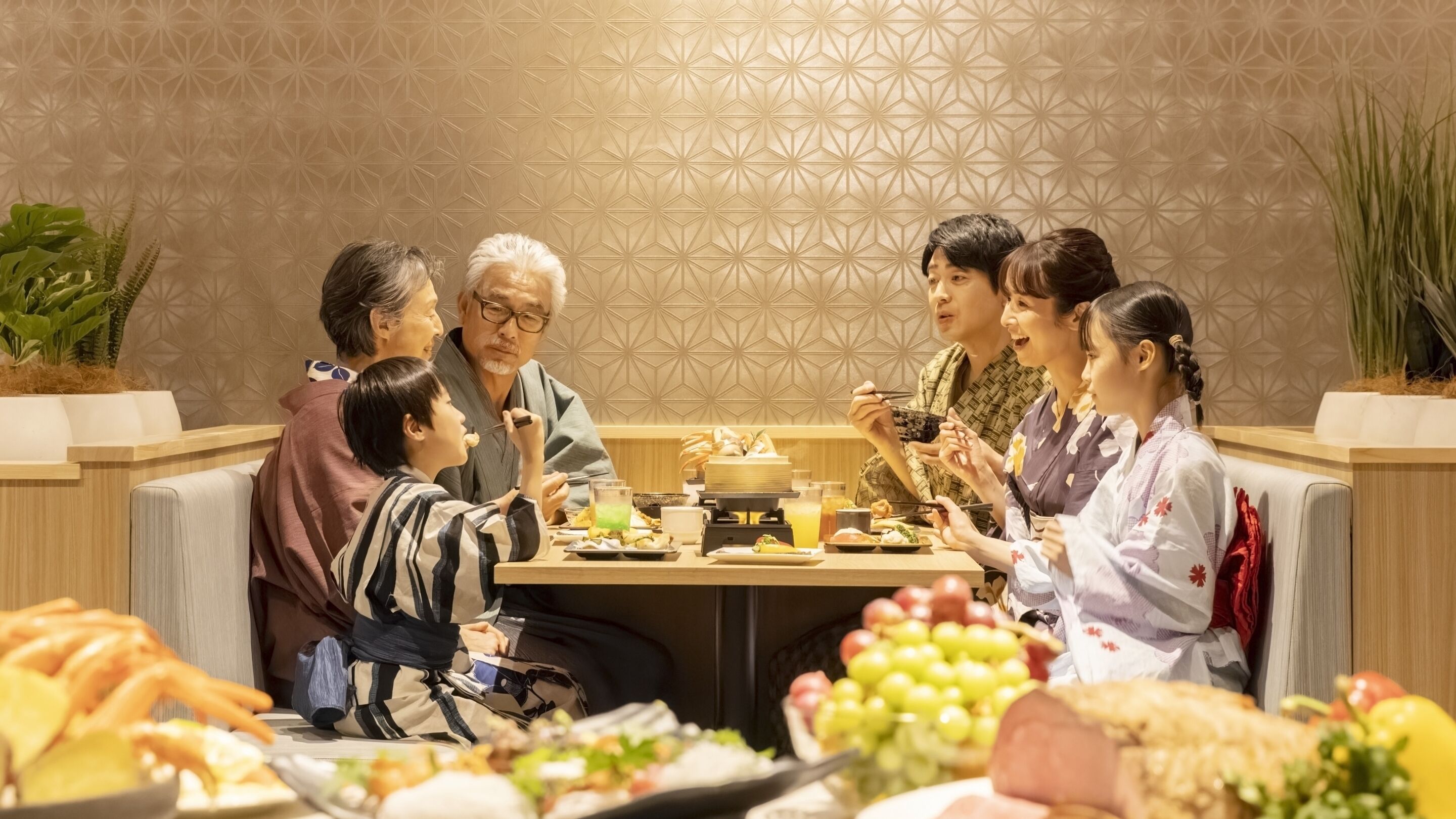 Um grupo de pessoas jantando à mesa, com diversos pratos e bebidas.