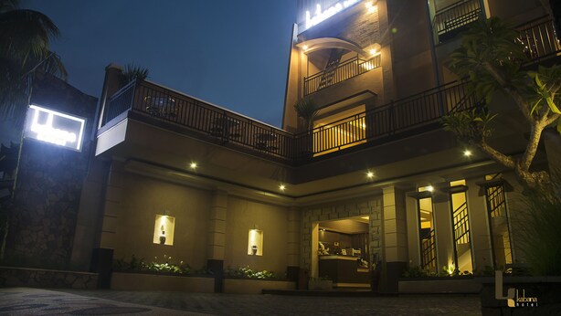 A hotel with a modern architectural design, featuring a central courtyard, multiple balconies, and a well-lit entrance. - Kabana Hotel (Mataram)