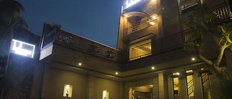 Vista frontal de la propiedad por la tarde o noche