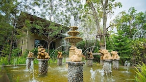 A garden with a central fountain and multiple statues. - Charming in Khao Yai Hotel (Pak Chong)