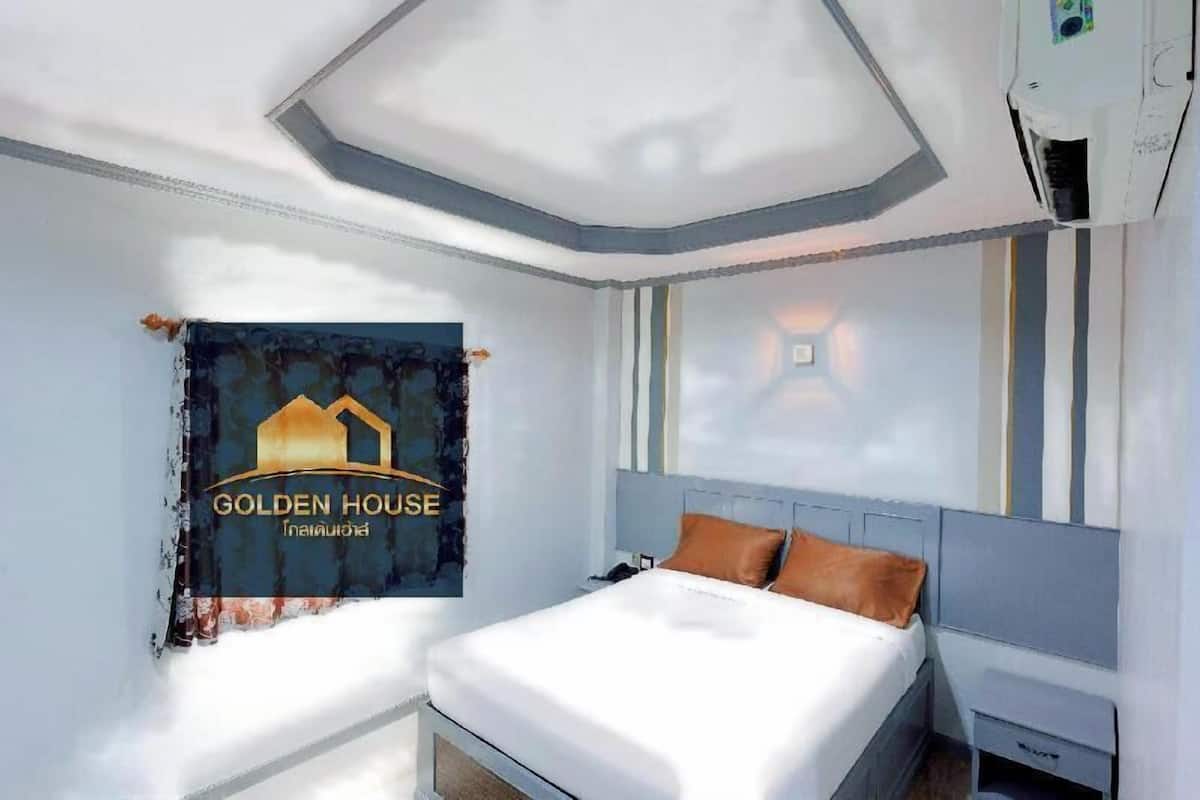 Une chambre d’hôtel comprenant un lit, une table de chevet, un climatiseur fixé au mur et un élément décoratif mural.