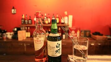 Un bar con botellas de whisky y una copa.