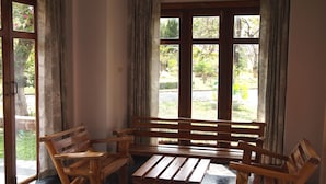 Eine Holzbank und zwei Stühle in einem Raum mit einem großen Fenster.