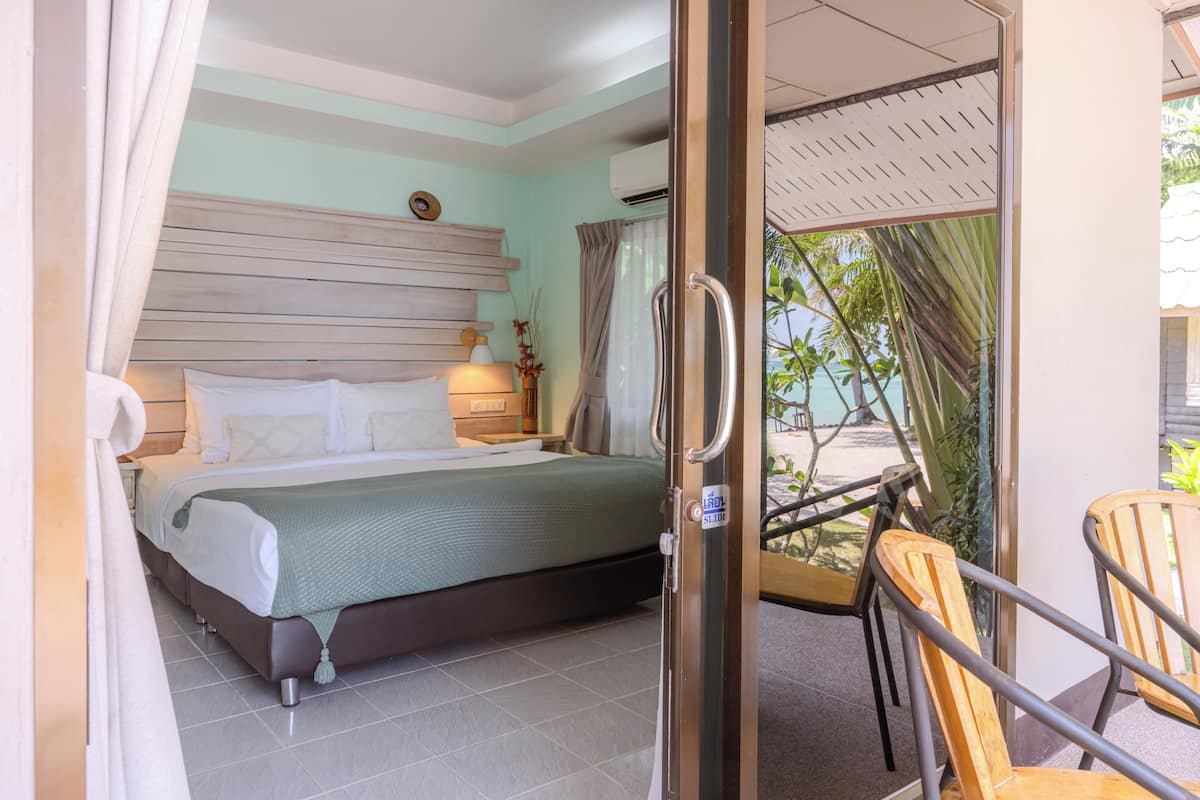 Un dormitorio con cama, mesita de noche y vistas al exterior.