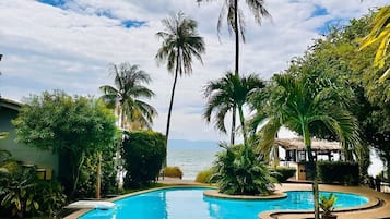 Una piscina al aire libre, camas de piscina gratis, sombrillas