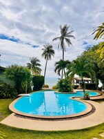 Una piscina al aire libre, camas de piscina gratis, sombrillas