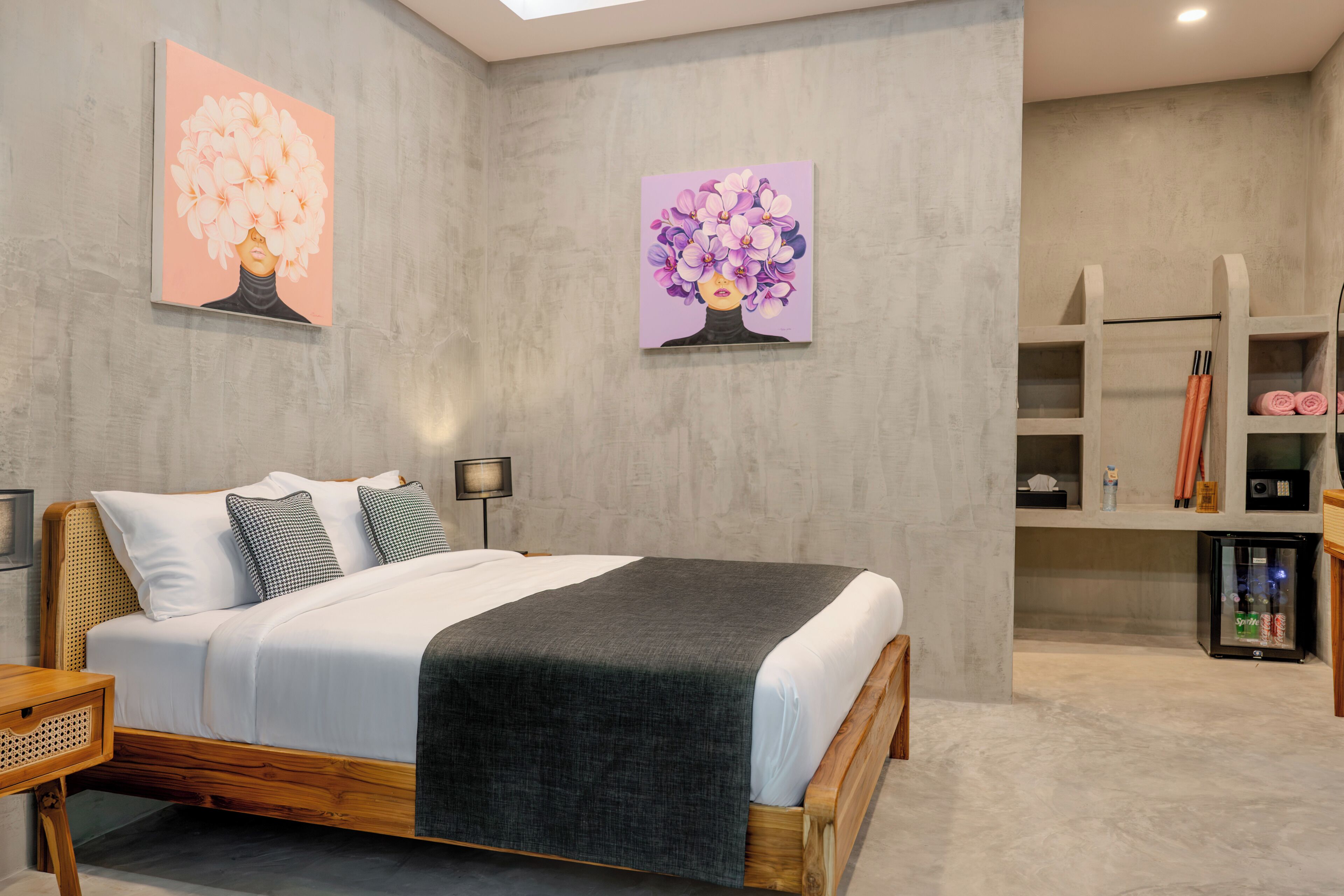 A modern bedroom with a bed, bedside tables, a wardrobe, and artwork on the walls.