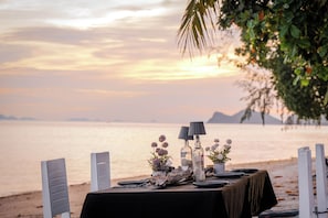 A table set for a meal with a view of the sea and mountains in the background. - Phangan Beach Resort (Ko Pha-ngan)