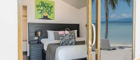 Un dormitorio con cama, mesita de noche, lámpara y un cuadro de un árbol.