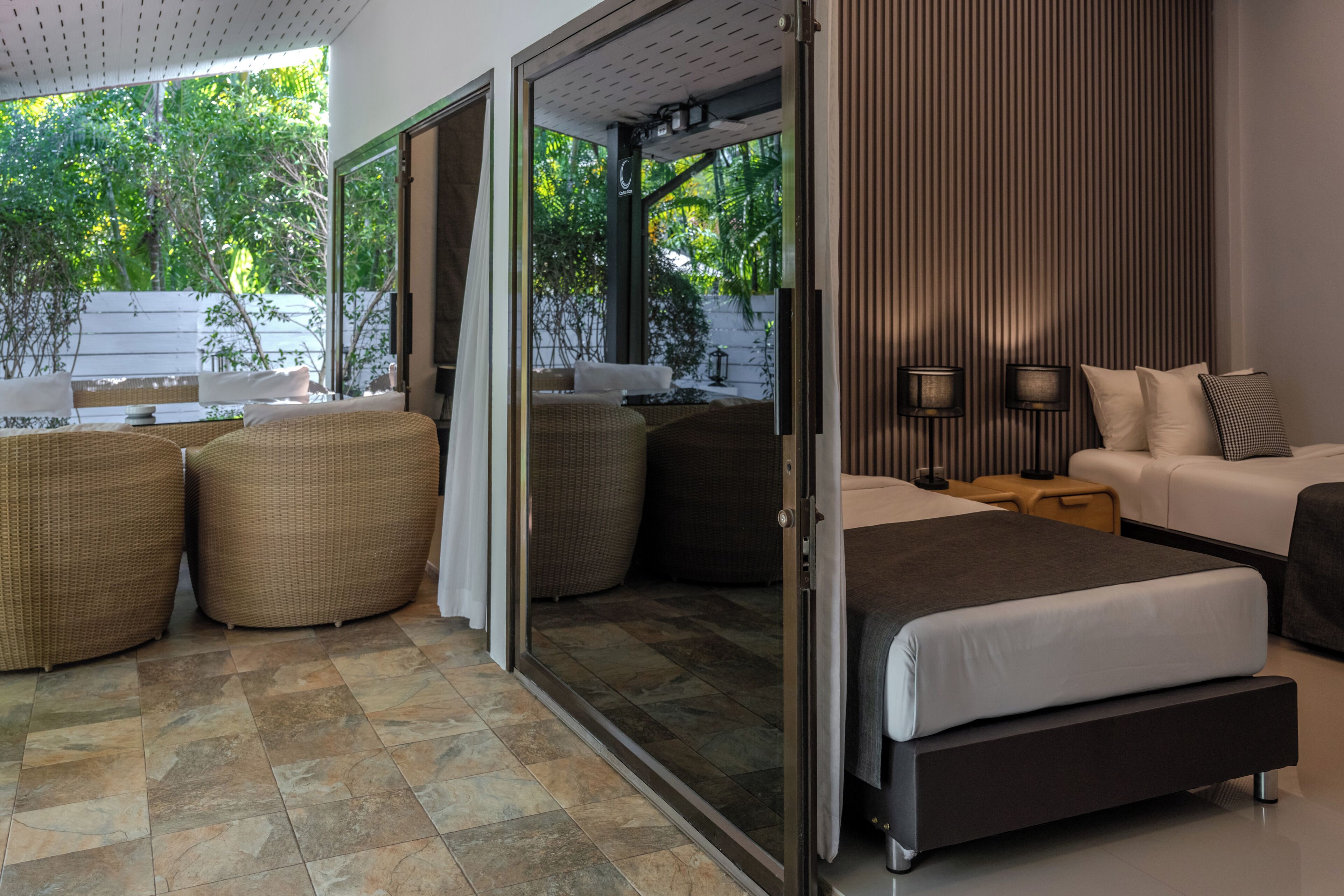 A modern bedroom with a bed, two sofas, and a dining area with a table and chairs.