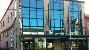 Un hôtel moderne doté de grandes fenêtres, d’une entrée bien visible et d’une enseigne indiquant qu’il s’agit d’un hôtel.