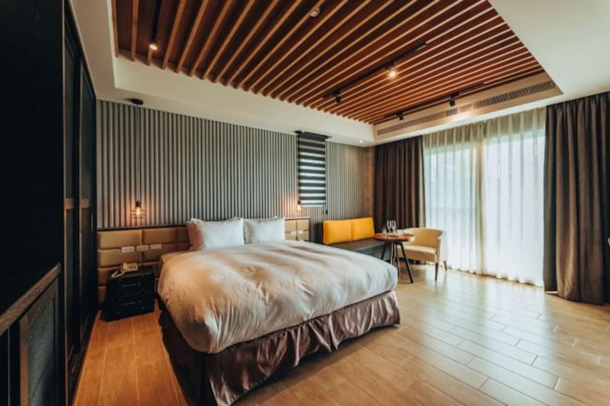 Une chambre d’hôtel moderne, dotée d’un grand lit, d’un bureau et d’une chaise.