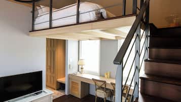 Un dormitorio tipo loft con una cama litera, un escritorio y un televisor.