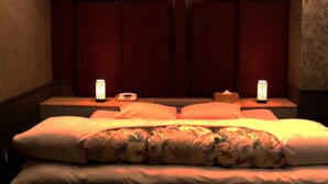 A hotel room with a bed, two bedside tables, and two wall-mounted lamps. - Hotel Alten (Osaka)