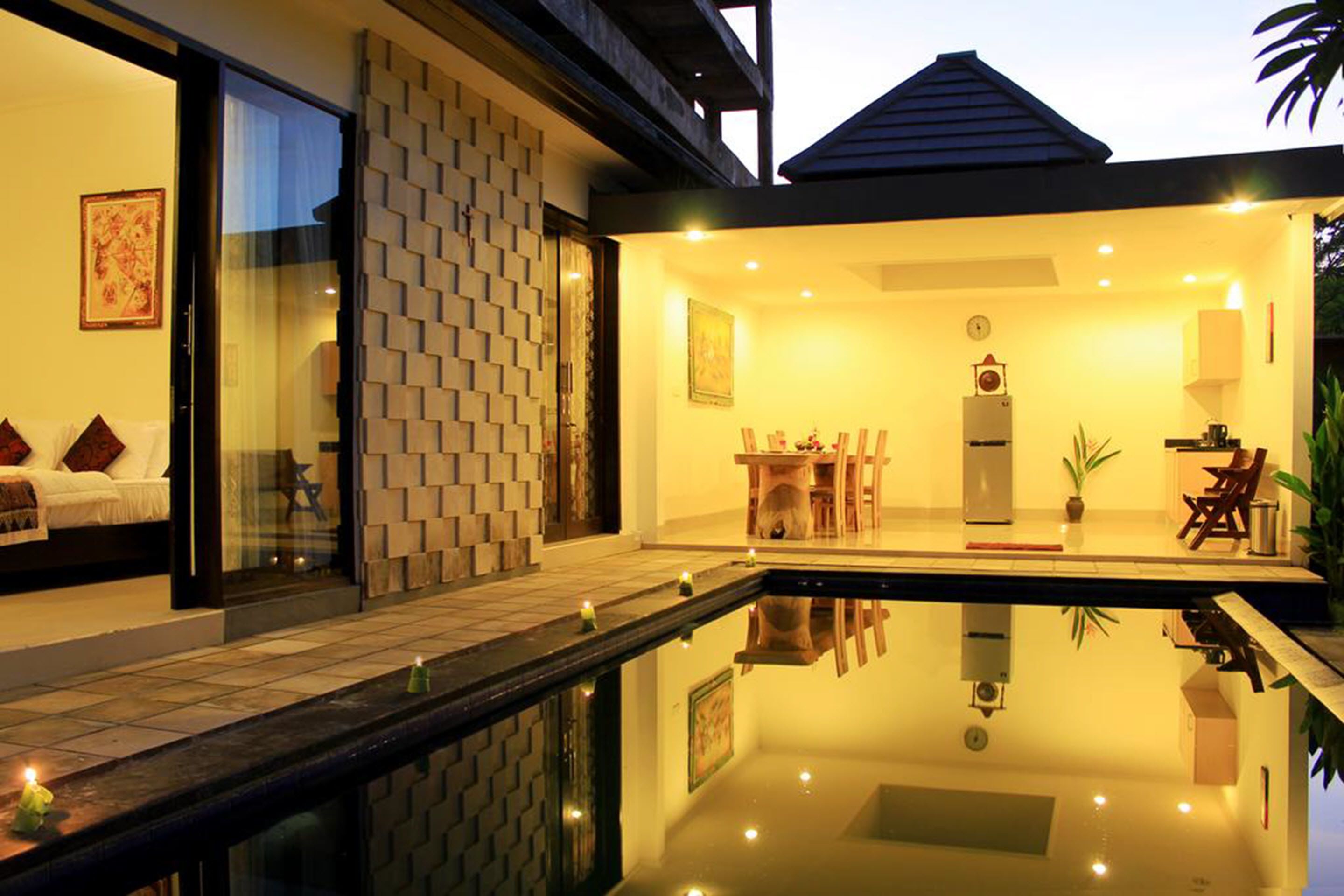 A modern house with a glass-enclosed bedroom, a dining area, and a kitchen.