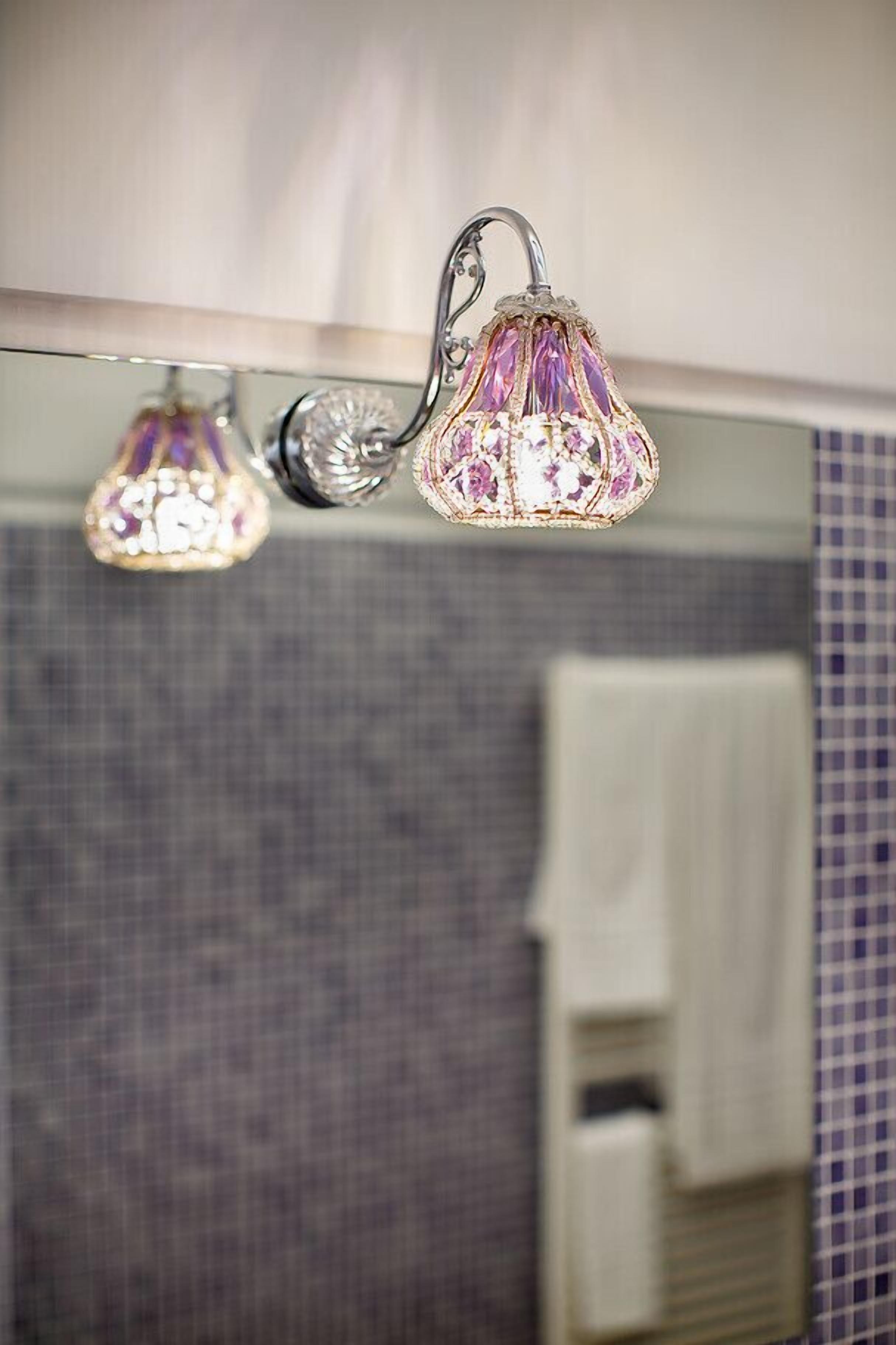 Une salle de bain avec un miroir, un porte-serviettes et une douche dotée d’une porte en verre.