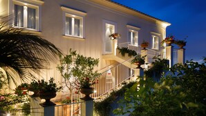 Un immeuble à plusieurs étages doté d’un balcon, de plantes en pot et d’un escalier.