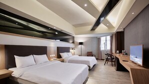 A modern hotel room with two beds, a desk, and a TV. - Unababy Hotel (Hengchun)