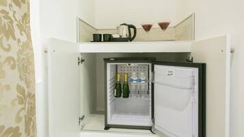 A refrigerator with a freezer compartment containing bottles and glasses.